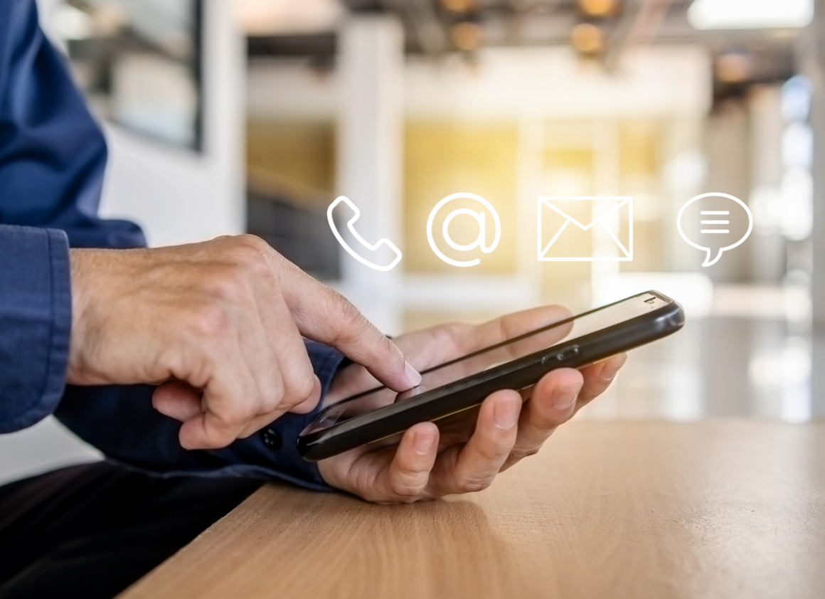 Close-up of a hand using a smartphone with floating contact icons including phone, email, and chat, representing multiple ways to reach Riverain Technologies support and sales teams.