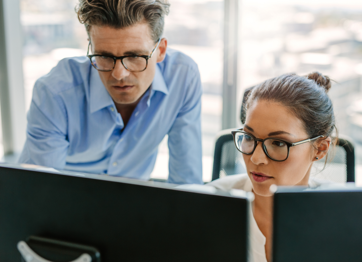 Two healthcare professionals review clinical data together at a workstation, reflecting Riverain Technologies' dedication to responsive technical support and customer service.